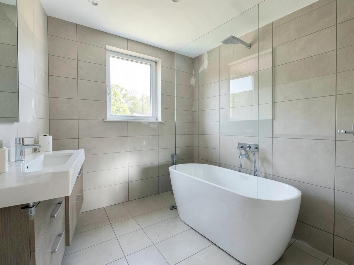 Newly remodelled bathroom with tiled walls and freestanding bath